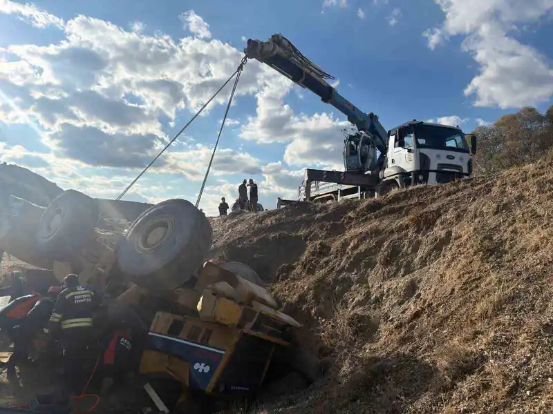 Devrilen iş makinesi altında kalan operatör kurtarıldı
