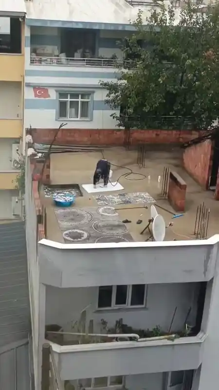 Yağmurlu havada çatıda halı yıkadı, görenler şaştı kaldı
