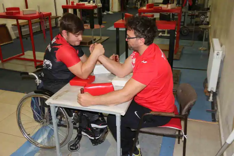 Aynı engele sahip olan öğrencisi ile bilek güreşi yapıyor
