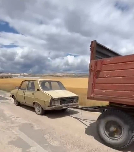 Otomobile gelişigüzel bağlanan traktör römorku trafiği tehlikeye düşürdü
